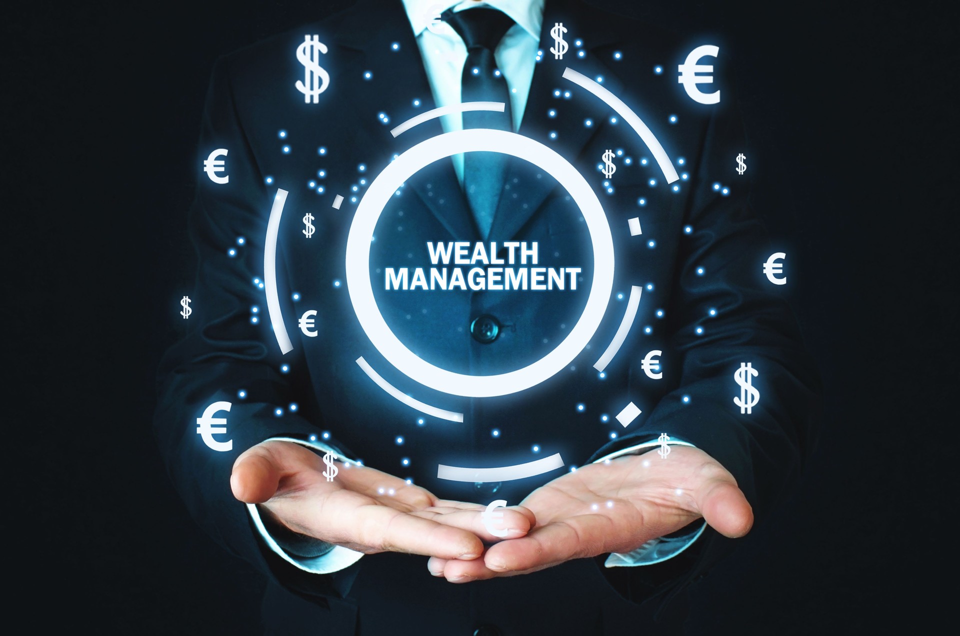Businessman holding Wealth Management word with currency symbols.