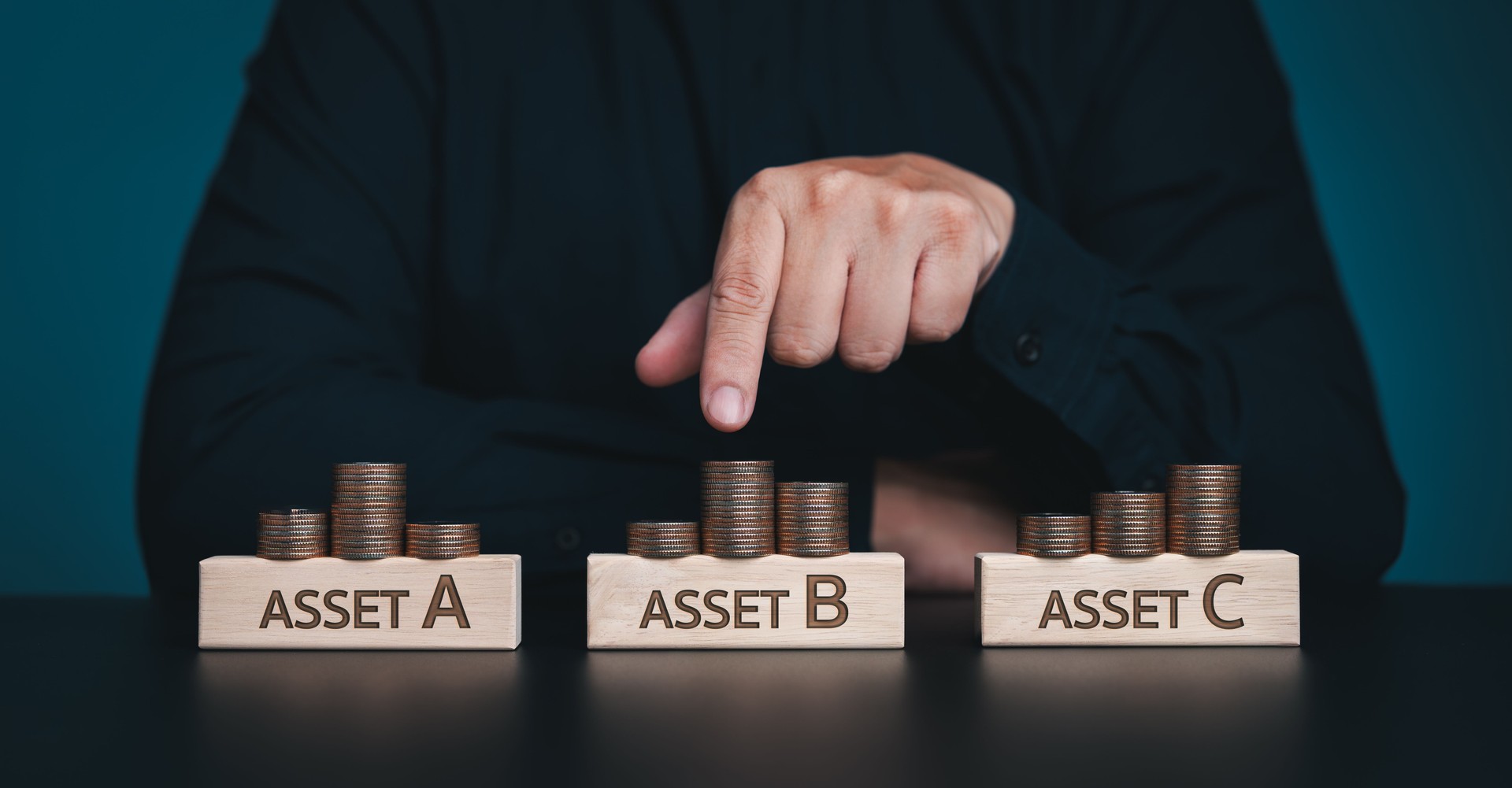 Diversify financial risk with funds. Investment asset allocation, diversification and risk management. Hand chooses on stacking coins with words ASSET A, B, C on wooden blocks. Real estate investment.